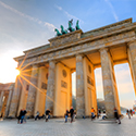 Das Brandenburger Tor beim Sonnenaufgang, die Sonnenstrahlen brechen sich in den Torsäulen